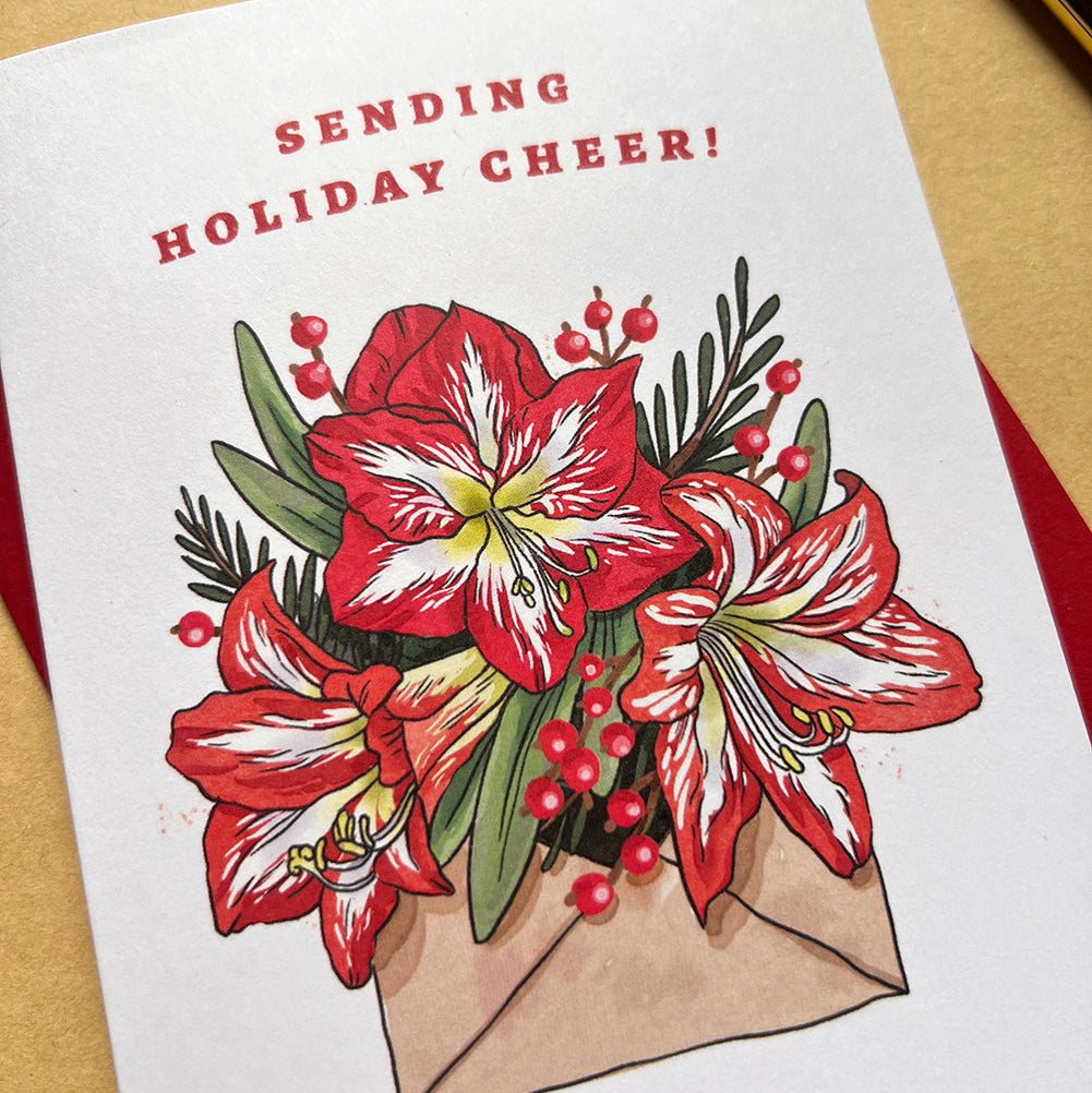 Greeting card with red flowers and 'Sending Holiday Cheer!' text on a beige background