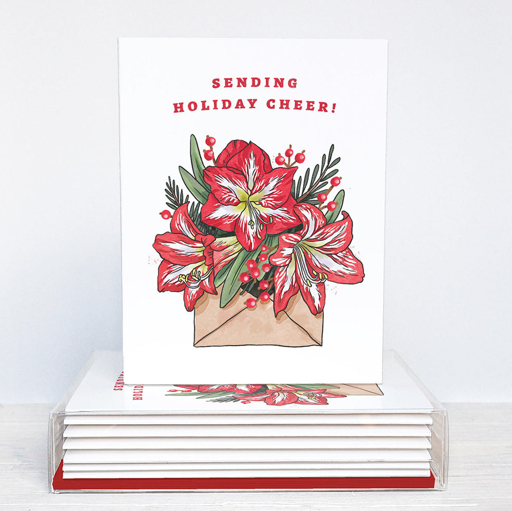 Stack of greeting cards with floral design and 'Sending Holiday Cheer!' text on a white background