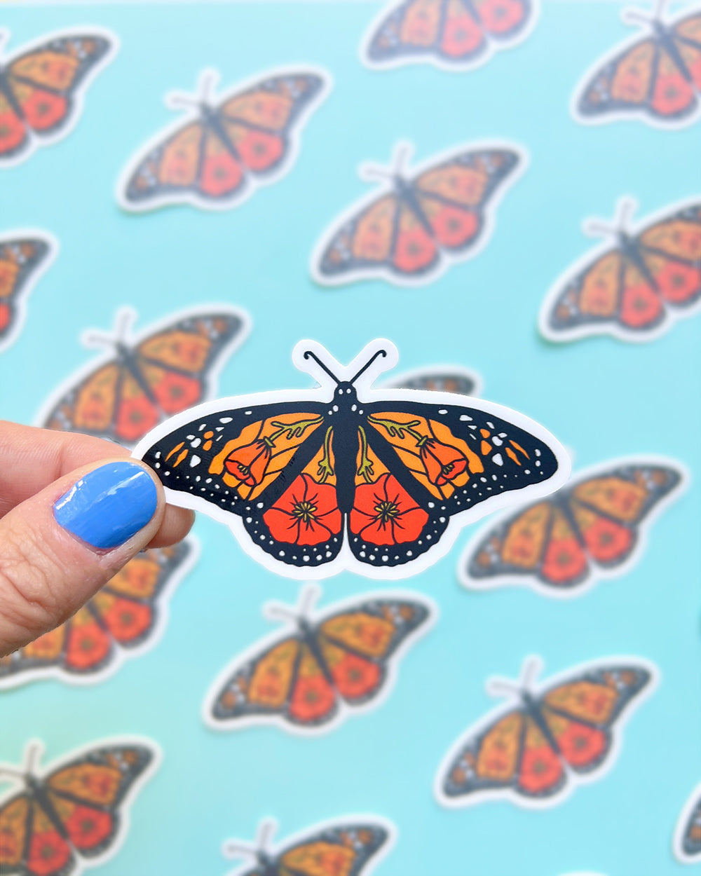 California poppy monarch sticker being held to show scale