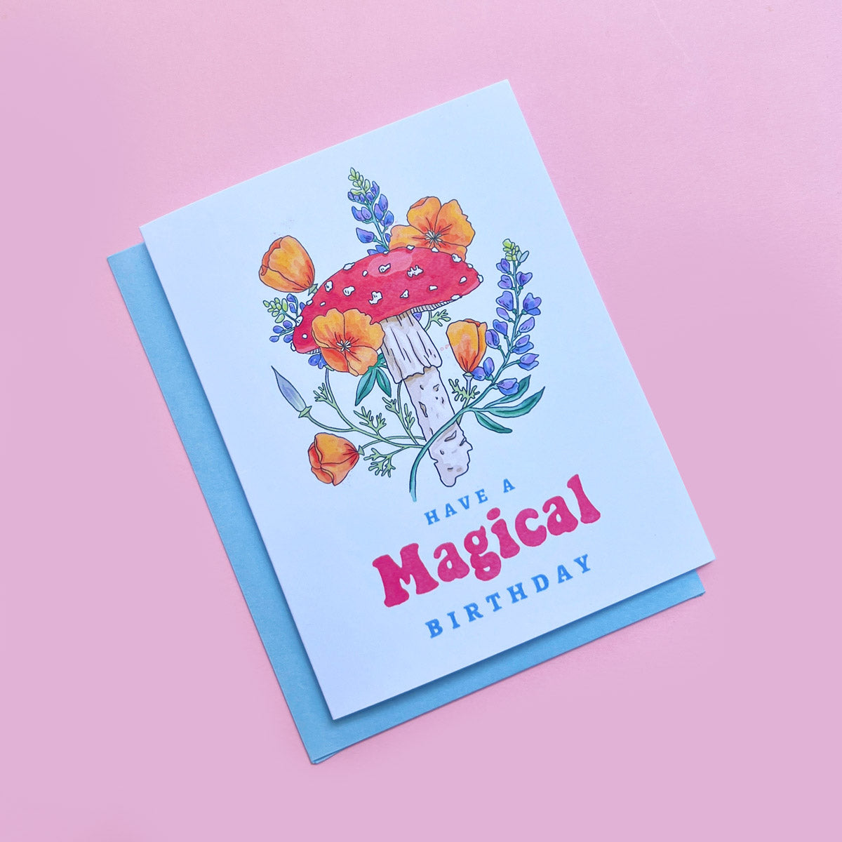 Greeting card with mushroom and floral design on a pink background