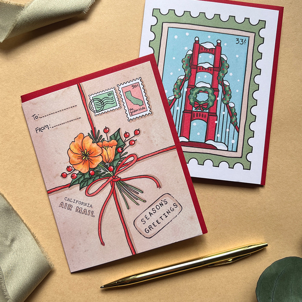 Two greeting cards with festive designs on a beige surface.