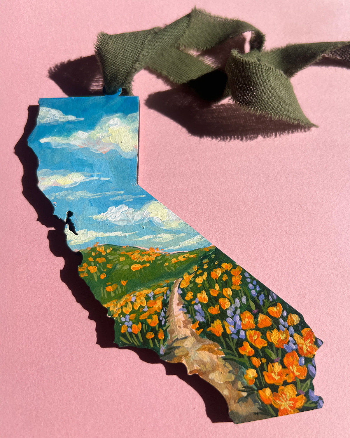 Painting of California with a scenic landscape on a pink background