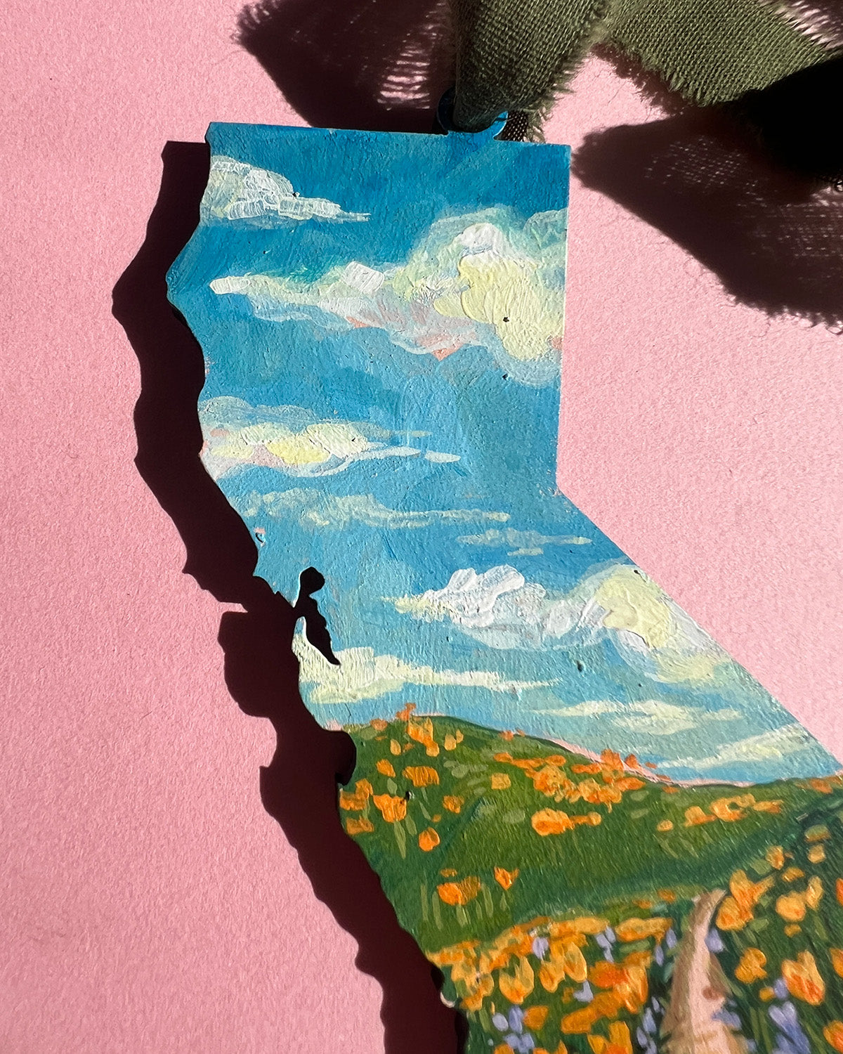 Painting of California with a stylized landscape on a pink background