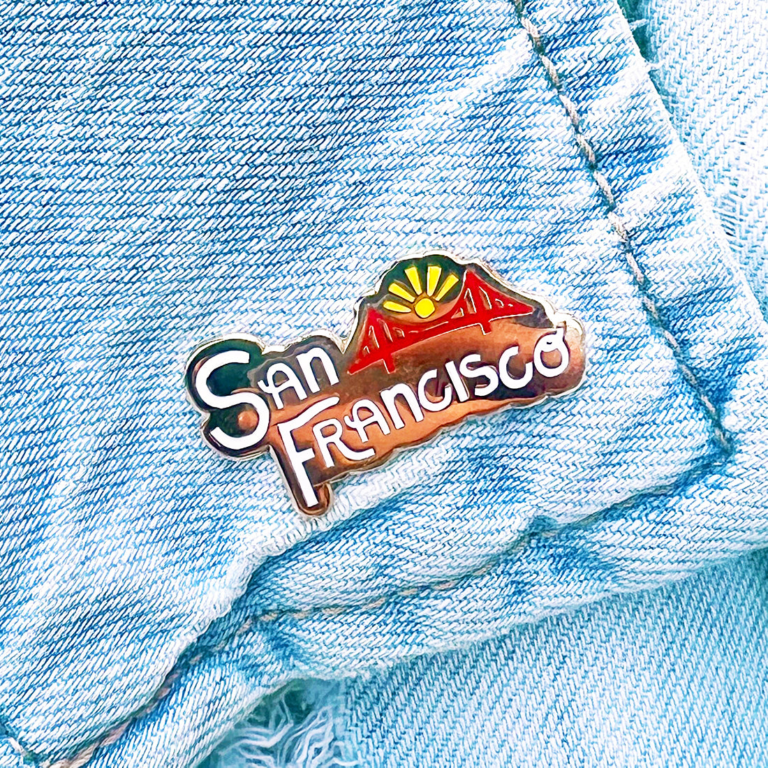 San Francisco lettering hard enamel pin shown on a denim jacket.