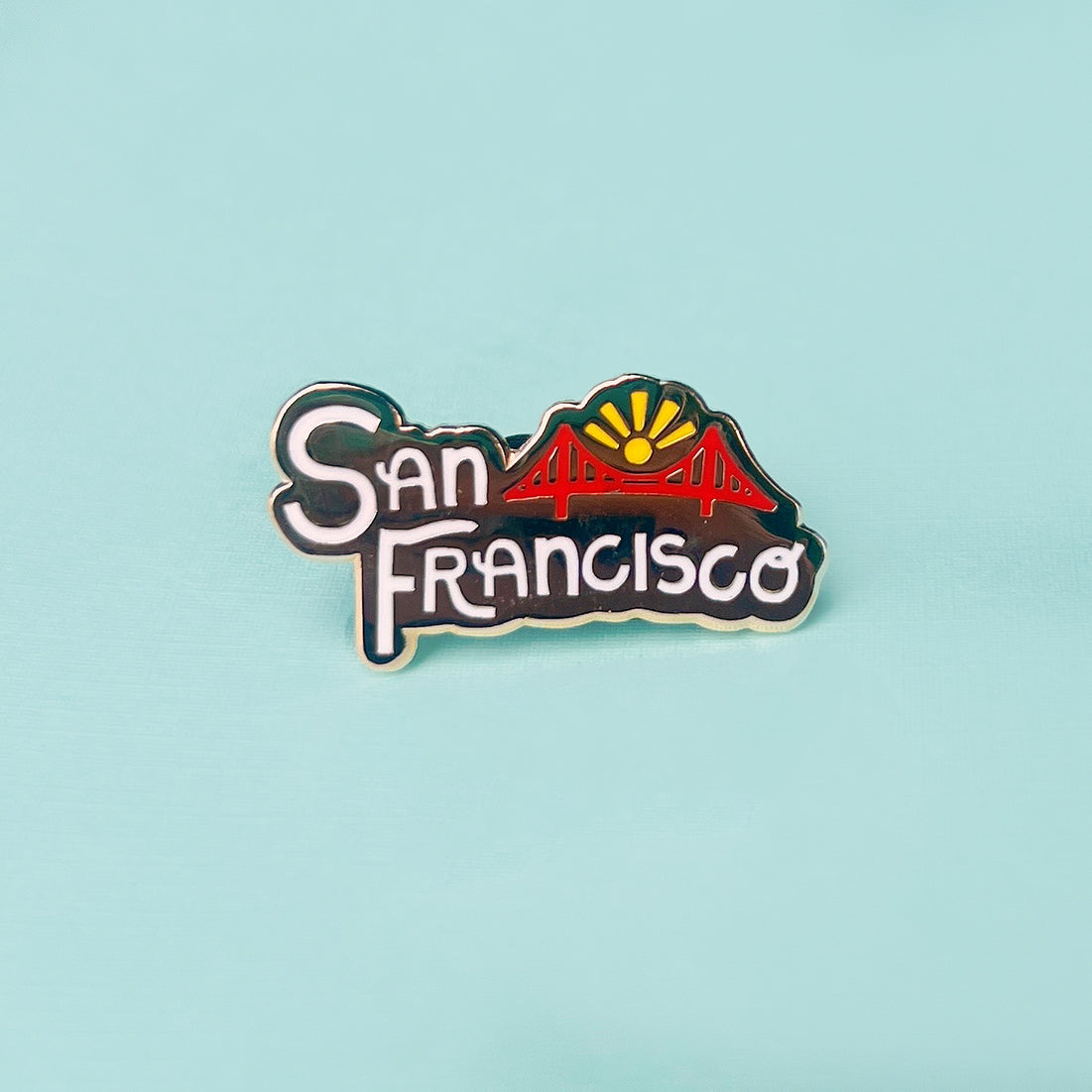 San Francisco lettering hard enamel pin on a light green background.